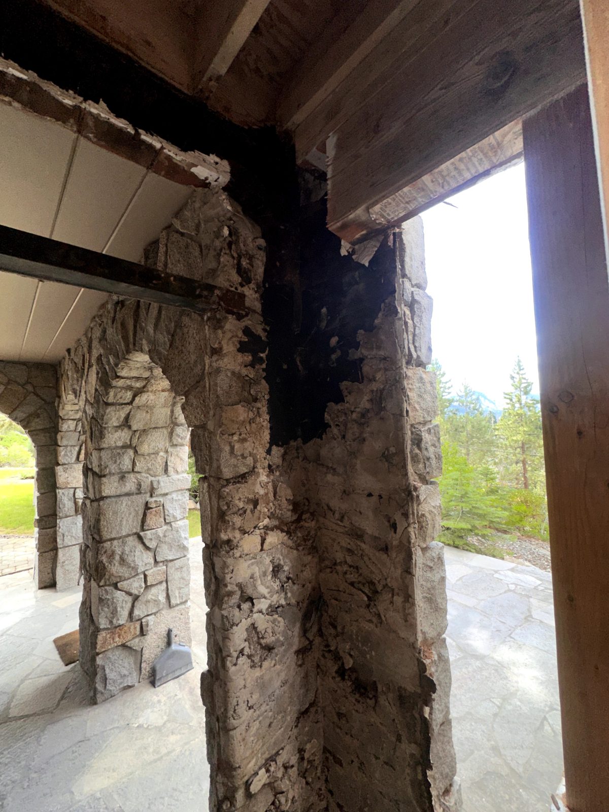 Wood rot damage on a deck post above a stone arch before repair, Lake Tahoe
